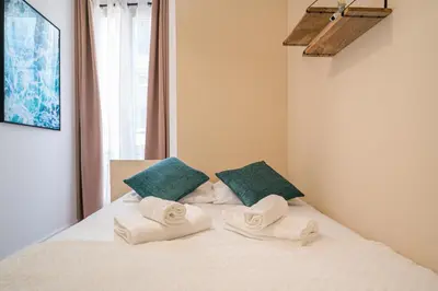a bedroom with a bed with towels on it at Guest House Chez Bastien in Nice