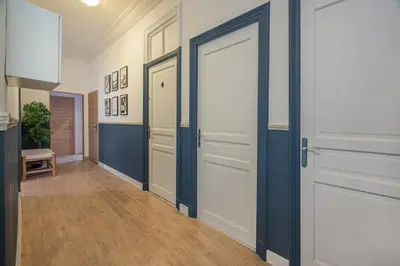 a hallway with white doors and wood floors at Guest House Chez Bastien in Nice