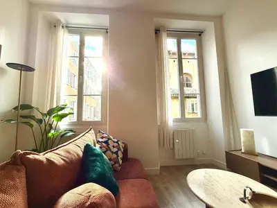 a living room with a couch and two windows at Magnifique 2 pièces - Vieux Nice in Nice