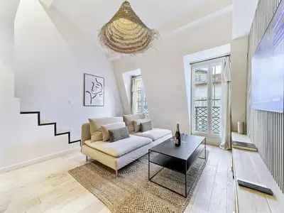 a living room with a couch and a table at Hyper Centre - Charming duplex - Luxury - Reversible air conditioning - 10 mins from Place MASSENA in Nice