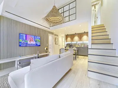 a living room with a white couch and a tv at Hyper Centre - Charming duplex - Luxury - Reversible air conditioning - 10 mins from Place MASSENA in Nice