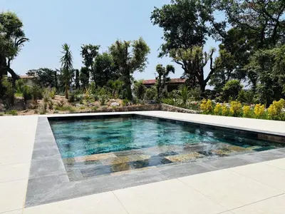 a swimming pool in the middle of a yard at L'Esprit Sud, 4 Suites & Piscine Chauffée in Vence