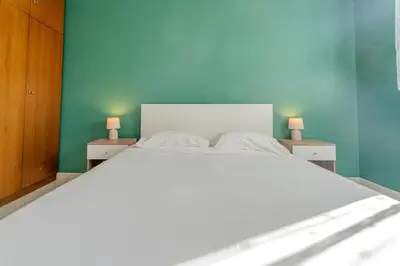 a white bed in a bedroom with two night stands at Sea & City View in Nice