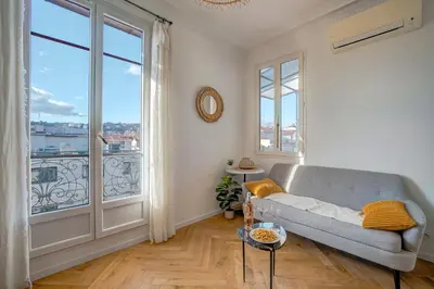 a living room with a couch and a large window at Maison Bianchi - Avenue Durante - Downtown Top floor in Nice