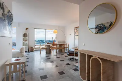a living room with a table and a mirror at LE SAINT ESTEVE AP4435 By Riviera Holiday Homes in Villefranche-sur-Mer
