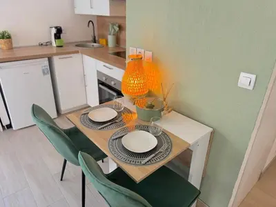 a small kitchen with a table with plates and chairs at ⁂ Calme et ensoleillé balcon quartier Port Nice in Nice