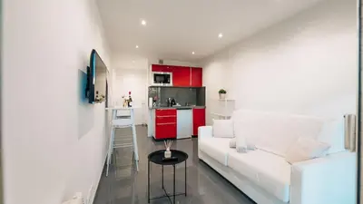 a living room with a white couch and a kitchen at Superbe studio front de mer in Saint-Laurent-du-Var