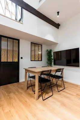 a dining room with a wooden table and chairs at Loft Spacieux pour 10 personnes avec Terrasse in Nice