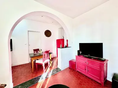 a living room with a tv and a red dresser at ApartHotel Riviera - CLOCHER D'ALEXANDRE - Old Town - Promenade des Anglais in Nice
