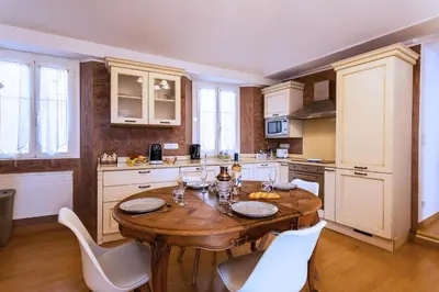 a kitchen with a wooden table and white cabinets at HEAVEN AP4440 By Riviera Holiday Homes in Villefranche-sur-Mer