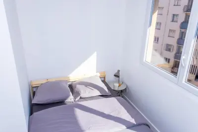 a bed in a white room with a window at NIce proche mer in Nice