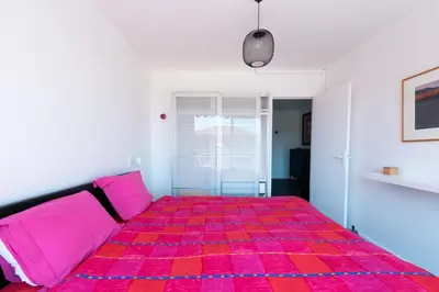 a bedroom with a pink bed and a couch at Happyfew Fodere in Nice
