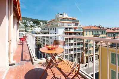 a balcony with a table and chairs on a building at Happyfew Fodere in Nice