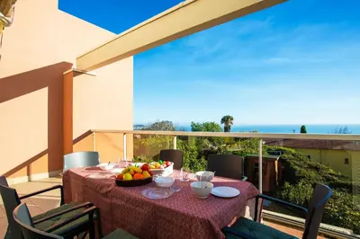a table with a bowl of fruit on a balcony at LE JARDIN BLEU AP4388 By Riviera Holiday Homes in Nice