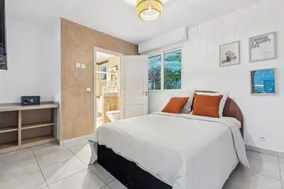 a white bedroom with a bed and a window at Bay of Angels by ecoflats in Nice