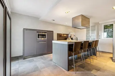 a kitchen with a bar with stools at Bay of Angels by ecoflats in Nice