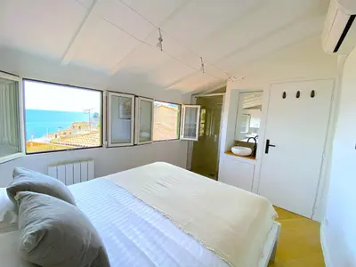 a bedroom with a bed with a view of the ocean at PEARL AP4444 By Riviera Holiday Homes in Villefranche-sur-Mer