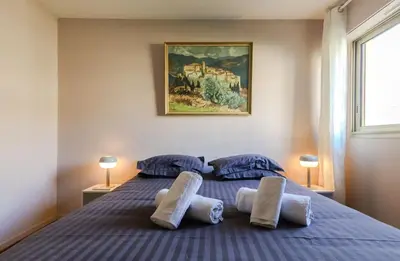 a bedroom with a blue bed with two pillows at Appartement cosy Cagnes-sur-Mer in Cagnes-sur-Mer