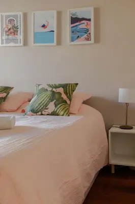 a bedroom with a bed with pink sheets and pillows at Appartement cosy Cagnes-sur-Mer in Cagnes-sur-Mer