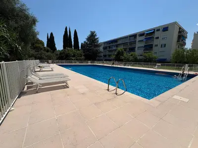 a swimming pool with a bench next to a building at NICE La Palmeraie Pool BEACH AC in Nice