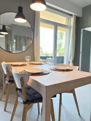 a dining room table with chairs and a mirror at NICE La Palmeraie Pool BEACH AC in Nice
