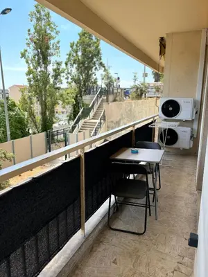 a balcony with a table and chairs on a building at NICE La Palmeraie Pool BEACH AC in Nice
