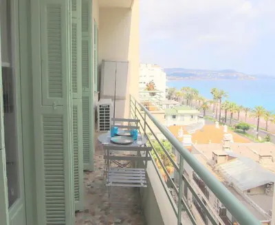 a balcony with a table and a view of the ocean at Happyfew Le Miramar in Nice