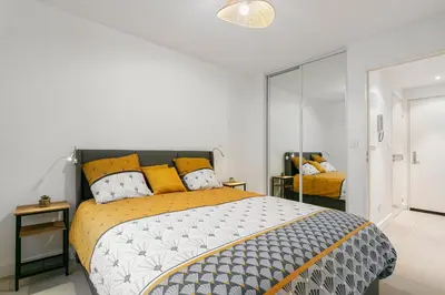 a bedroom with a large bed with yellow pillows at Suite Matisse FSHH - Generale in Nice