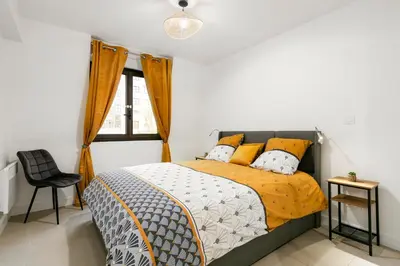a bedroom with a bed with orange and white pillows at Suite Matisse FSHH - Generale in Nice