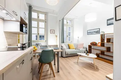a kitchen and living room with a couch and a table at FEEL HOME - Poissonnerie in Nice