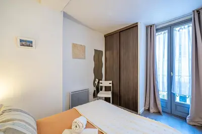 a bedroom with a bed and a large window at Vieux-Nice 2P climatisé Balcon in Nice