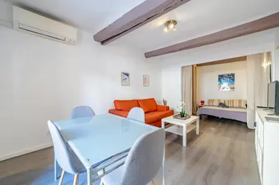 a living room with a table and a couch at Vieux-Nice 2P climatisé Balcon in Nice