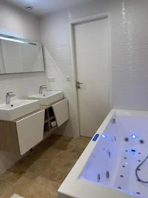 a bathroom with two sinks and a large tub at Maison avec jacuzzi privatif dans résidence in La Gaude