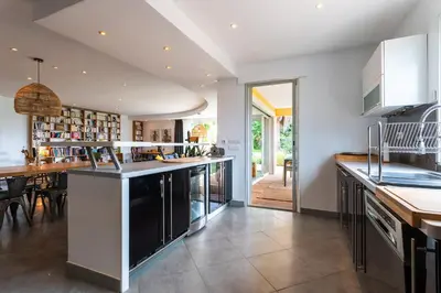 a kitchen with a large island and a dining room at VILLA NIDAZUR VI4413 By Riviera Holiday Homes in Nice
