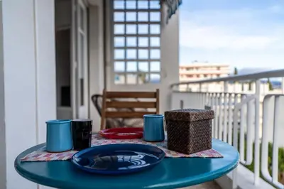 a table with a plate of food on a balcony at Il Sole e Mare in Nice