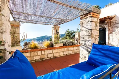 a patio with a bed and a view of a yard at CASA ROSALIE VI4442 By Riviera Holiday Homes in Villefranche-sur-Mer