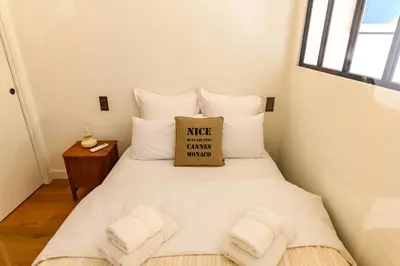 a small bedroom with a white bed with a pillow at Hyper Centre, balcon, 5min de la plage, AC in Nice
