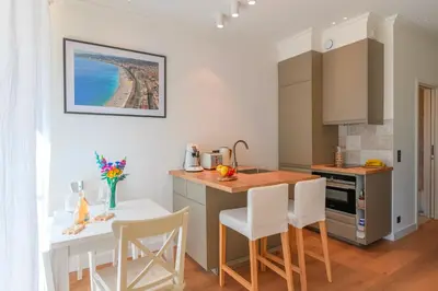 a kitchen with a table and chairs and a counter top at Hyper Centre, balcon, 5min de la plage, AC in Nice