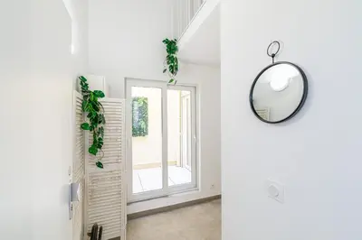 a hallway with a mirror and a window at 1 Bdr Duplex Downtown - AC in Nice