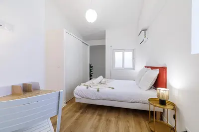 a white bedroom with a bed and a window at 1 Bdr Duplex Downtown - AC in Nice