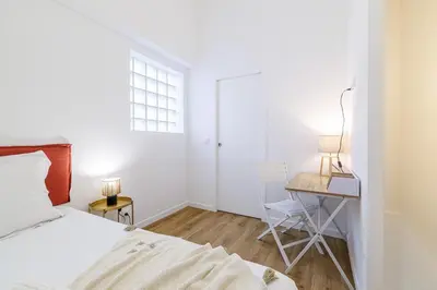 a bedroom with a bed and a desk with a lamp at 1 Bdr Duplex Downtown - AC in Nice