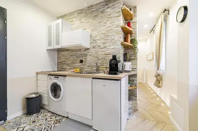 a kitchen with a washing machine and a stone wall at Ultra Central 1 Bdr - AC in Nice