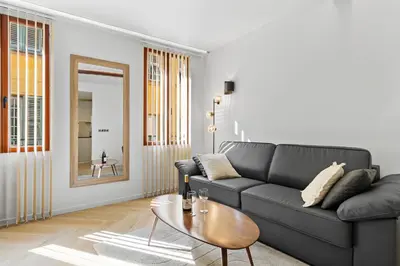 a living room with a black couch and a table at Saint-Augustin - Nice Old Town in Nice