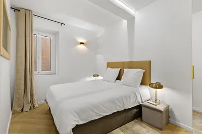 a white bedroom with a large bed and a window at Saint-Augustin - Nice Old Town in Nice