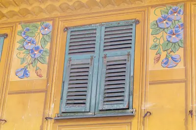 a window with flowers painted on the side of a building at Saint-Augustin - Nice Old Town in Nice