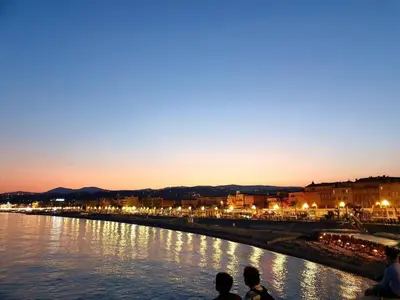 a group of people sitting next to a river at night at Studio T1 Centre - Idéal couple & amis - Confort - WIFI - Calme - Climatisation - Coin Terrasse in Nice