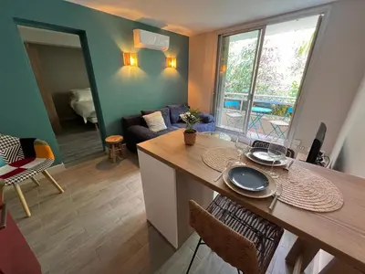 a kitchen with a table and a living room at Les Magnolias 06 in Nice