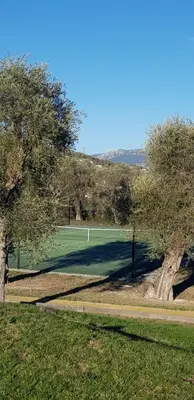 a tennis court with a net in a field at Laconsolate in Nice