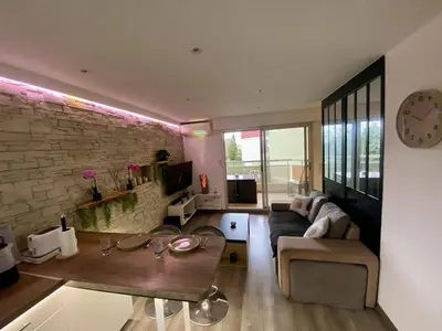 a living room with a couch and a table at F1 Saint Laurent du Var Proximity to beach-Clim Wifi in Saint-Laurent-du-Var