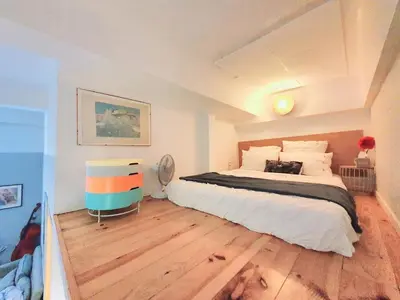 a bedroom with a large bed and wooden floors at 3 rooms GEM in Old Town Nice in Nice